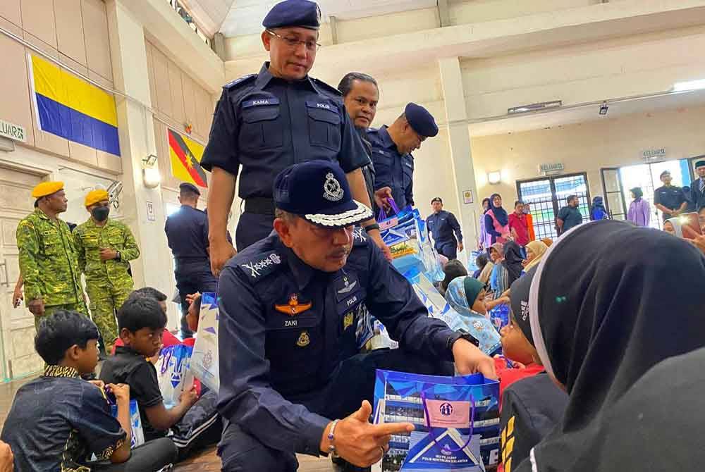 Muhamad Zaki menyampaikan sumbangan kepada kanak-kanak yang tinggal di PPS Sekolah Kebangsaan (SK) Sri Rantau Panjang Dua pada Selasa.