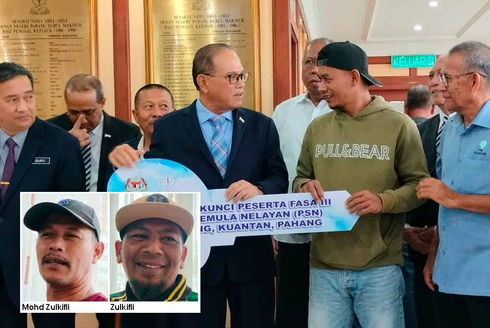 Wan Rosdy menyerahkan replika kunci kepada salah seorang daripada 16 penerima pada majlis penyerahan kunci rumah Projek Perumahan Penempatan Semula Nelayan Bunut Rendang di Wisma Sri Pahang pada Selasa.
