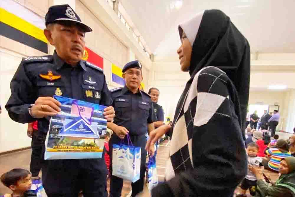 Muhamad Zaki (kiri) mendengar perkongsian pengalaman berdepan banjir oleh seorang remaja ketika lawatan di PPS SK Sri Rantau Panjang Dua.