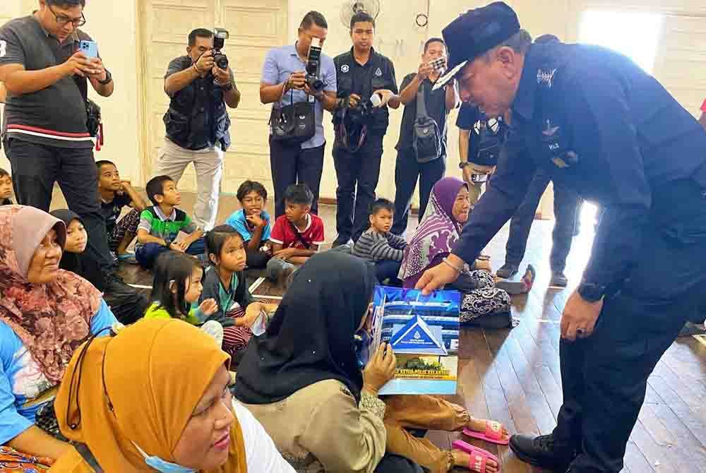 Muhamad Zaki (kanan) beramah mesra dengan penghuni PPS SK Sri Rantau Panjang Dua pada Selasa.