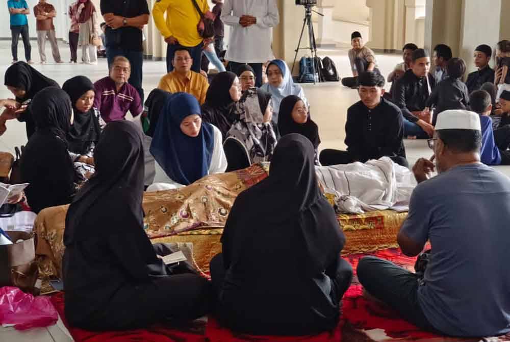Norhasliyana (tudung biru) setia di sisi jenazah Allahyarham untuk disembahyangkan di Masjid Tuminah Hamidi, Bagan Datuk.