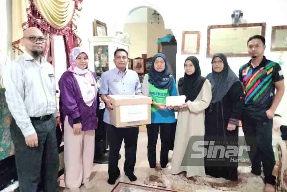 Nur Hasifah (tiga dari kanan) menerima sumbangan daripada Nora.