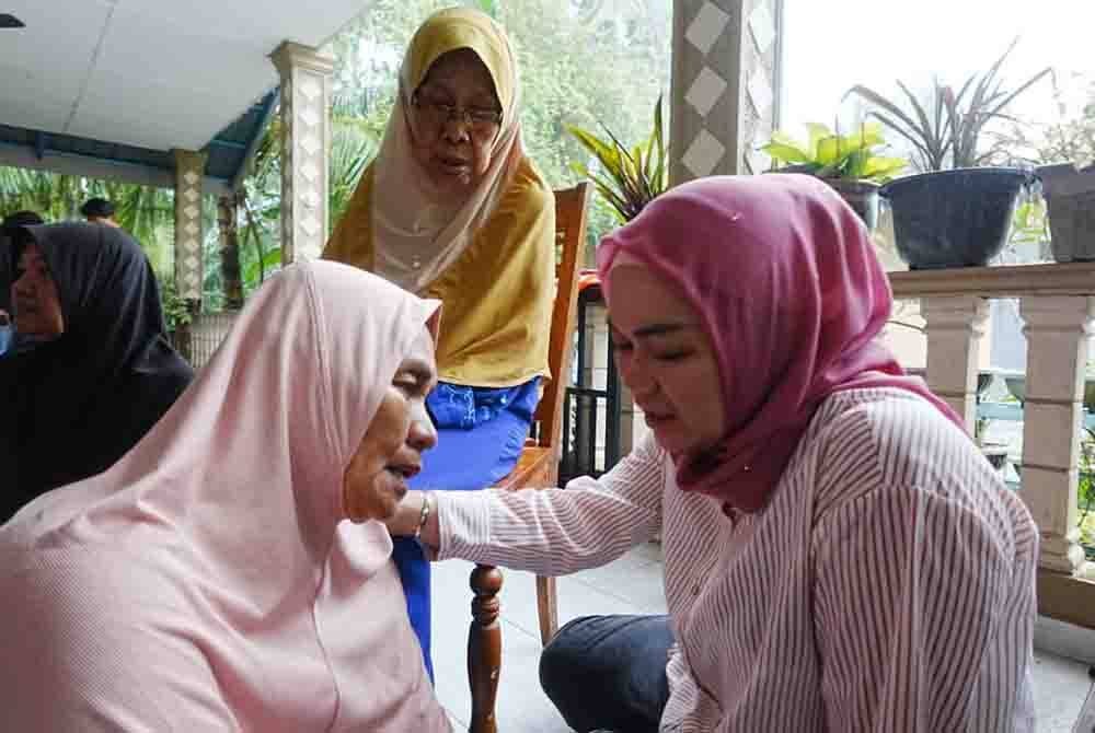 Nurul Syazwani (kanan) menziarahi Martiah (kiri) selepas terlibat dalam kebakaran rumah pada Selasa.