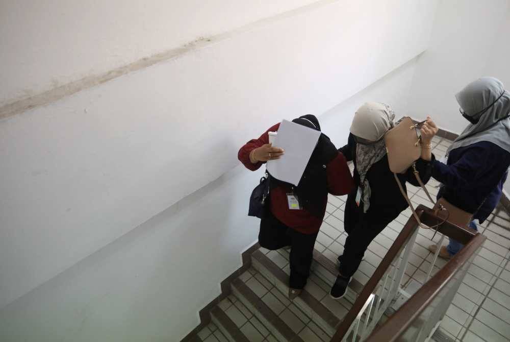 Tertuduh (tengah) ketika dihadapkan ke Mahkamah Majistret di Kuala Terengganu pada Rabu.