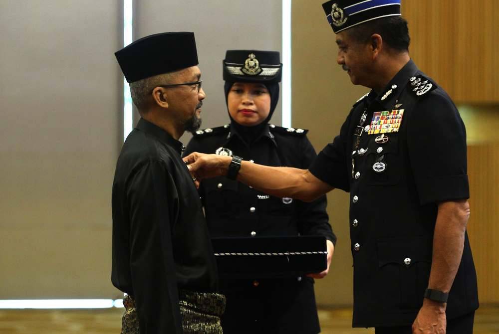 Razarudin memakai pingat kepada penerima semasa Majlis Istiadat Penganugerahan Pingat Jasa Pahlawan Negara Kontinjen Negeri Sembilan, di sini pada Rabu.