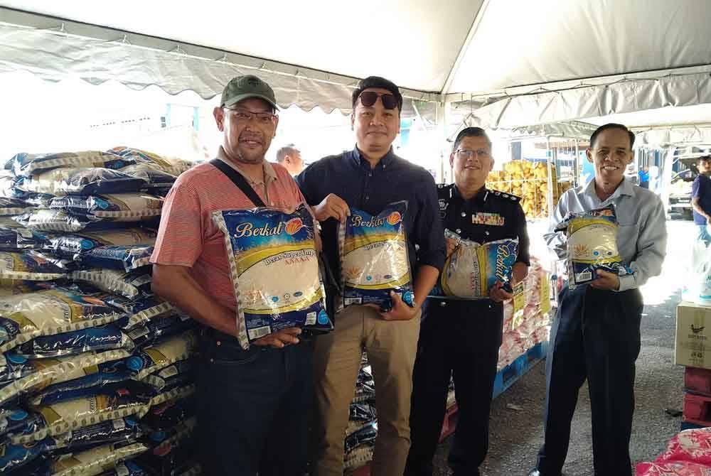 Mohamed Nordin (dua dari kanan) menunjukkan beras 5kg yang dijual pada harga RM15 menjadi tumpuan orang ramai sempena Program Jualan Rahmah di IPD Manjung pada Rabu.