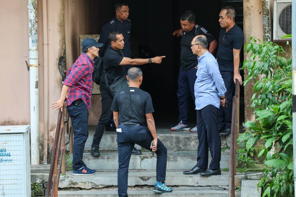 Mohd Shuhaily kiri) bersama anggota polis memasuki Blok R, Apartmen Idaman, Damansara Damai pada Rabu. - Foto Bernama
-- fotoBERNAMA (2023) HAK CIPTA TERPELIHARA