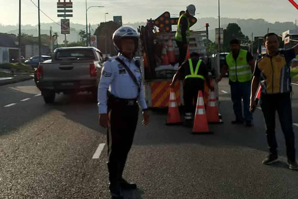Polis dan petugas JKR membuat kawalan berikutan laluan di MRR2 Hulu Kelang yang berlubang pada Selasa.