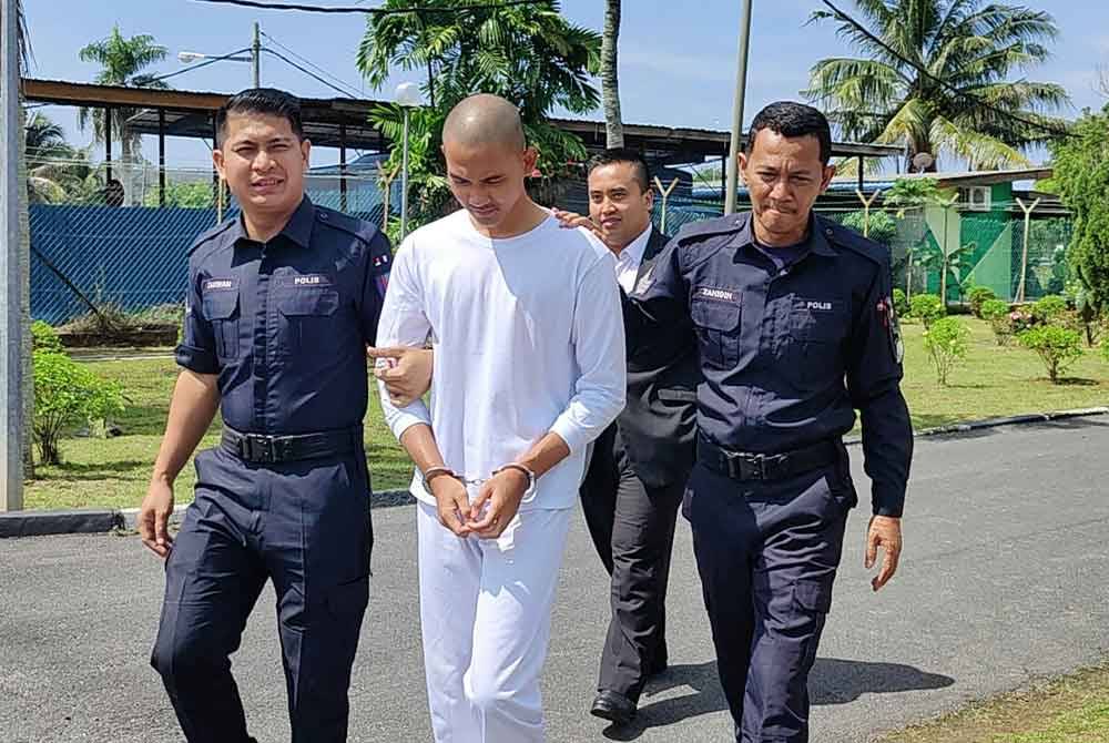 Muhammad Fakrul Aiman (tengah) diiringi polis dibawa ke Mahkamah Majistret Sungai Besar pada Khamis.