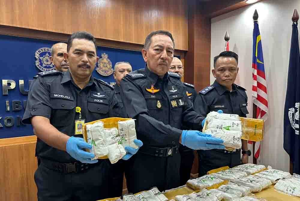 Muhamad Zaki (tengah) menunjukkan bungkusan yang mengandungi pil kuda.