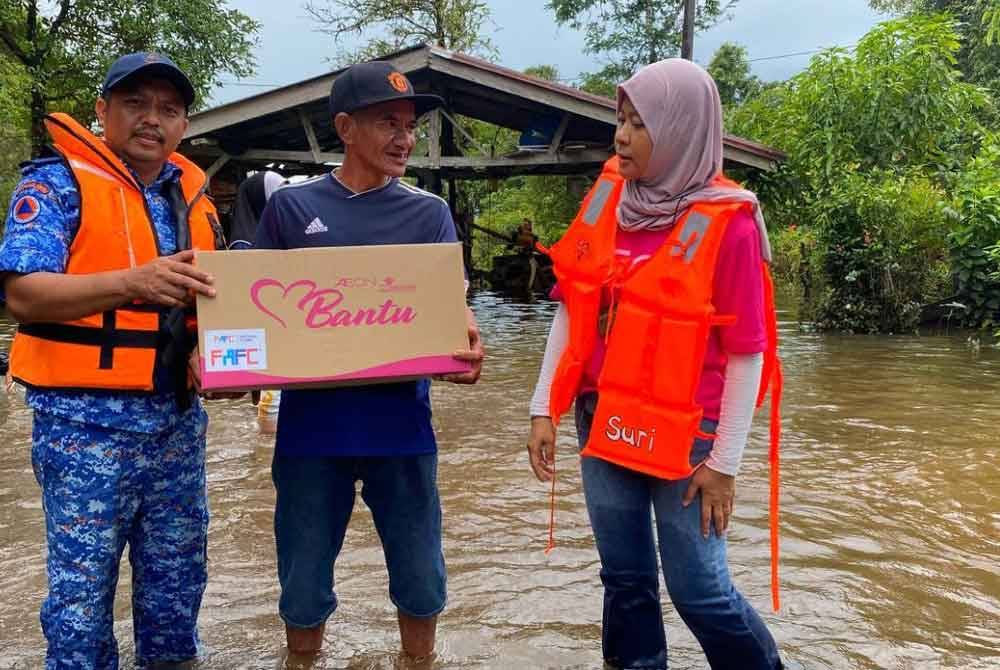 Che Mohd Rozi (dua dari kanan) berkongsi pengalaman banjir termenung yang berlaku menyebabkan dia dan lima lagi ahli keluarga terpaksa tinggal di PPS selama seminggu.