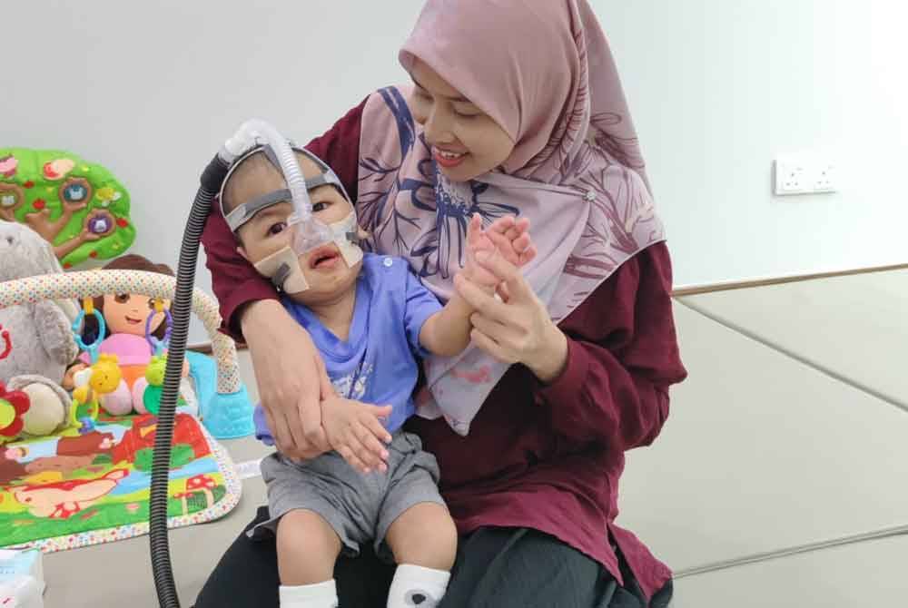 Nur Azizah memangku anaknya, Athif.