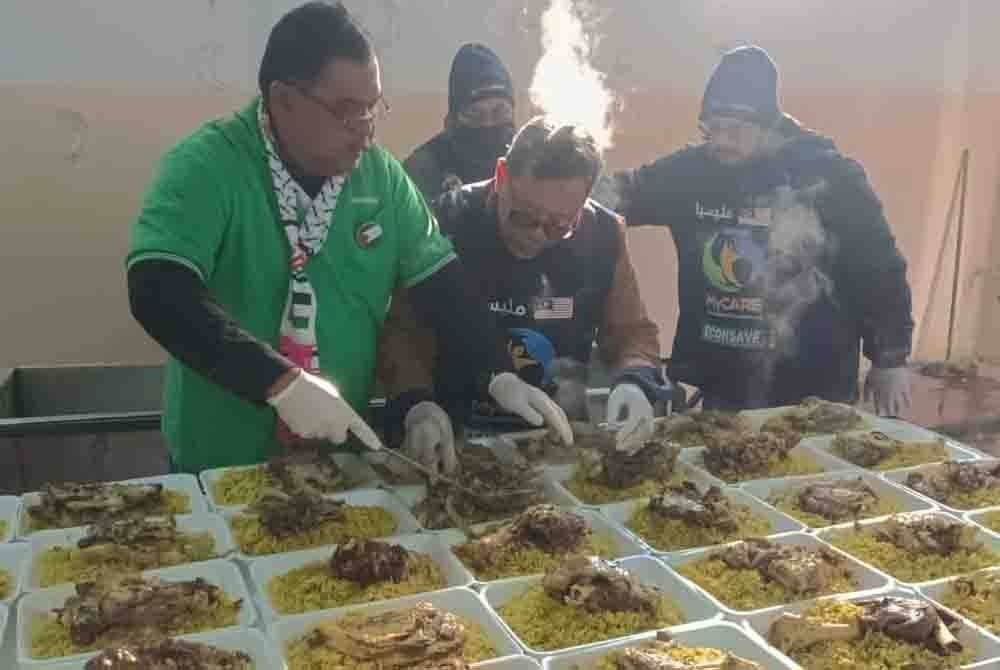 Dari kanan Rozi, Dr Mohd Zin dan Mas Imran menyediakan pek makanan sebelum dihantar ke beberapa kem pelarian sekitar Abad, Syria pada Khamis.