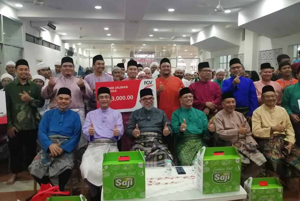 Rastam (duduk, tiga dari kiri) bersama wakil PPZ-MAIWP dan pengurusan masjid serta penerima sumbangan dana wakalah FGV di Masjid Rahimah Kampung Pandan.