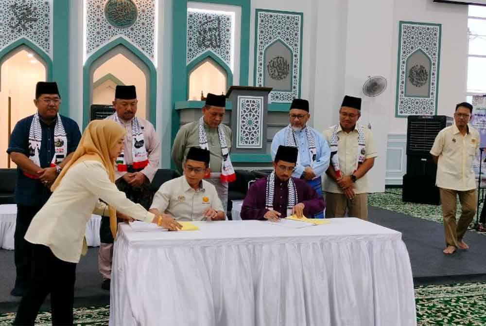 Aminuddin (empat dari kiri) ketika hadir merasmikan masjid berkenaan pada Jumaat