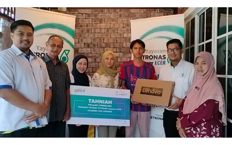 Faris (dua dari kanan) menyampaikan sumbangan komputer riba kepada Tuan Nafiezul Afiq yang memperoleh keputusan cemerlang SPM 2022.