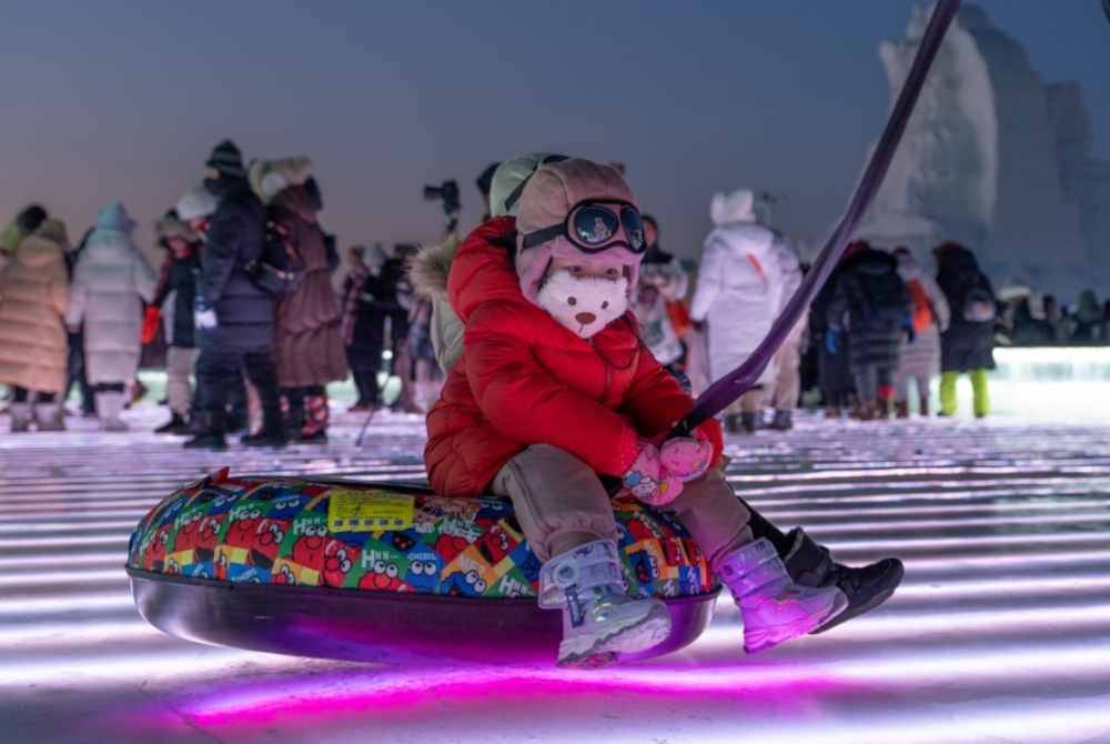 Seorang kanak-kanak bermain luncur ais. Foto: XINHUA