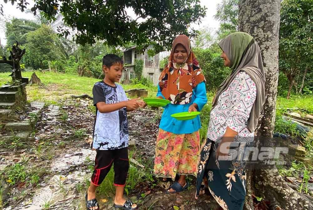 Che Hasmani (kanan) dan jirannya menunjukkan pinggan yang digunakan oleh mangsa dan dibawa lari oleh kera terbabit.