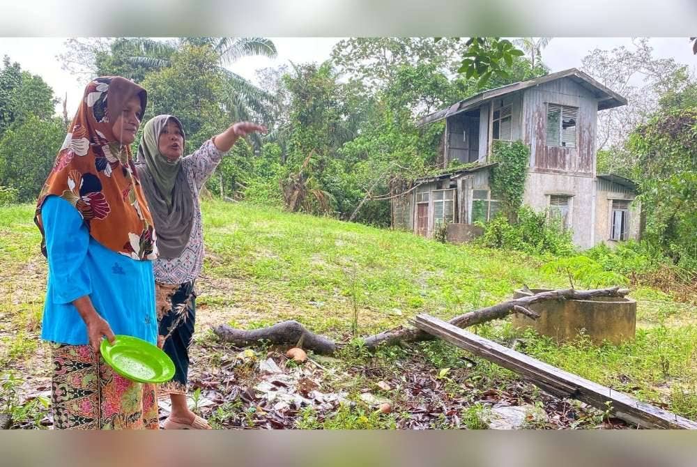 Che Hasmani (kanan) dan Siti Aisyah menunjukkan kawasan yang sering menjadi pilihan kera liar di Kampung Melati, Jalan Jirat Cina, Kuala Krai.