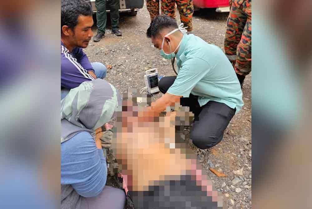 Pegawai perubatan cuba memberikan rawatan kepada mangsa di lokasi.