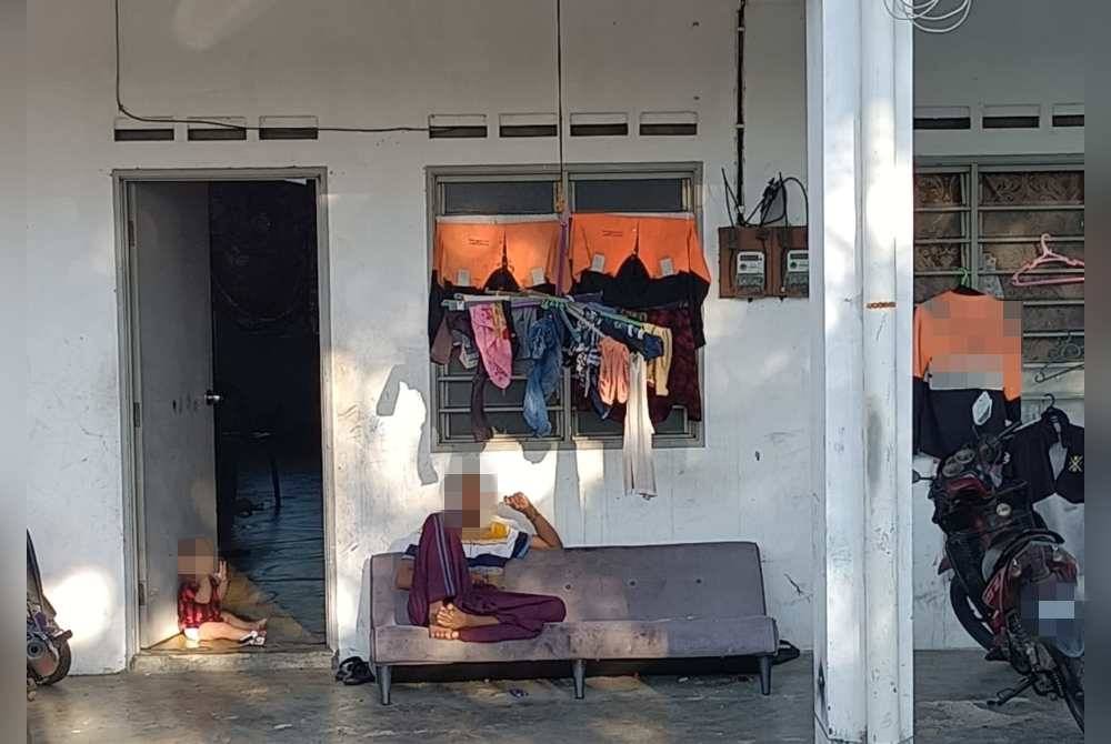 Seorang lelaki warga Rohingya di hadapan rumah sewa yang didiami mereka.