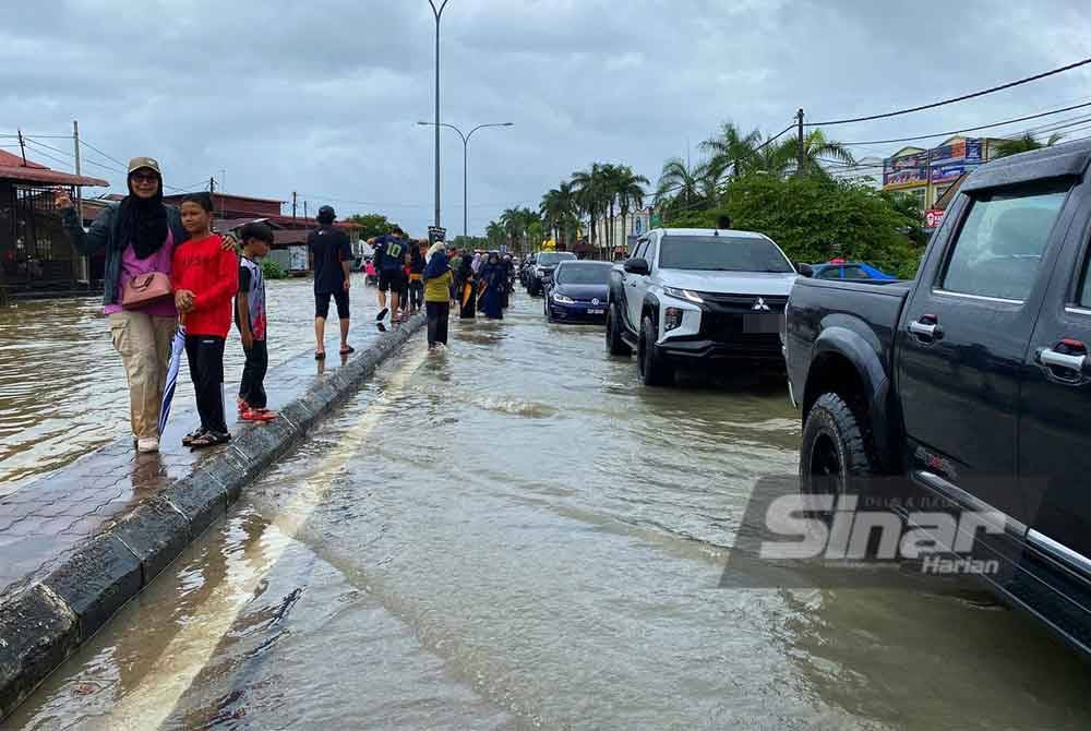 Orang ramai memenuhi kawasan di Rantau Panjang untuk melihat suasana banjir.