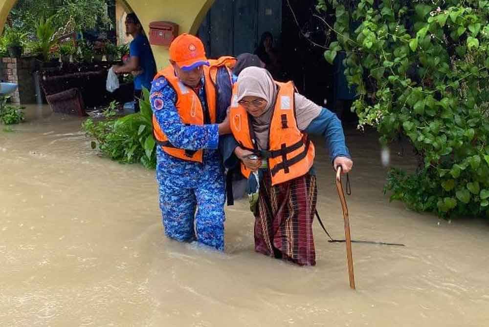 Anggota APM membantu warga emas berpindah di Baroh Pial, Rantau Panjang.