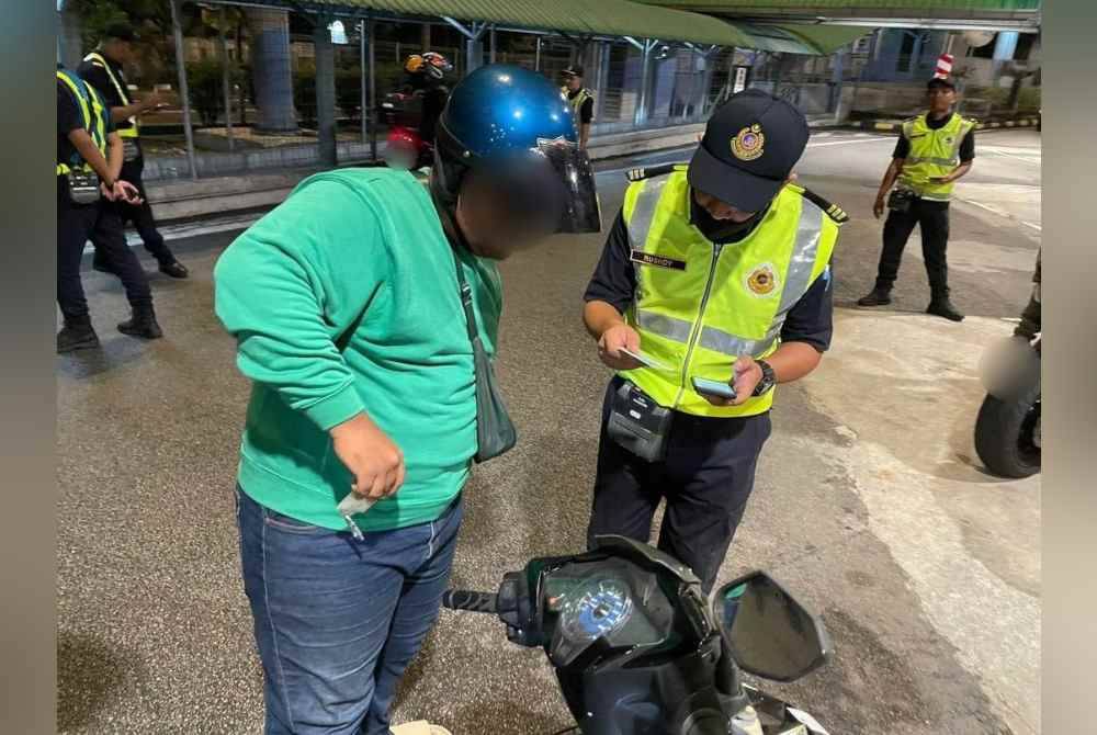 Anggota JPJ Pulau Pinang sedang memeriksa salah sebuah motosikal dalam Ops Khas Ambang Krismas yang dijalankan pada malam 24 Disember lalu.