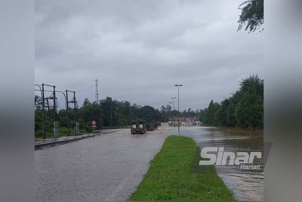 Lori ATM membawa orang ramai meredah banjir.