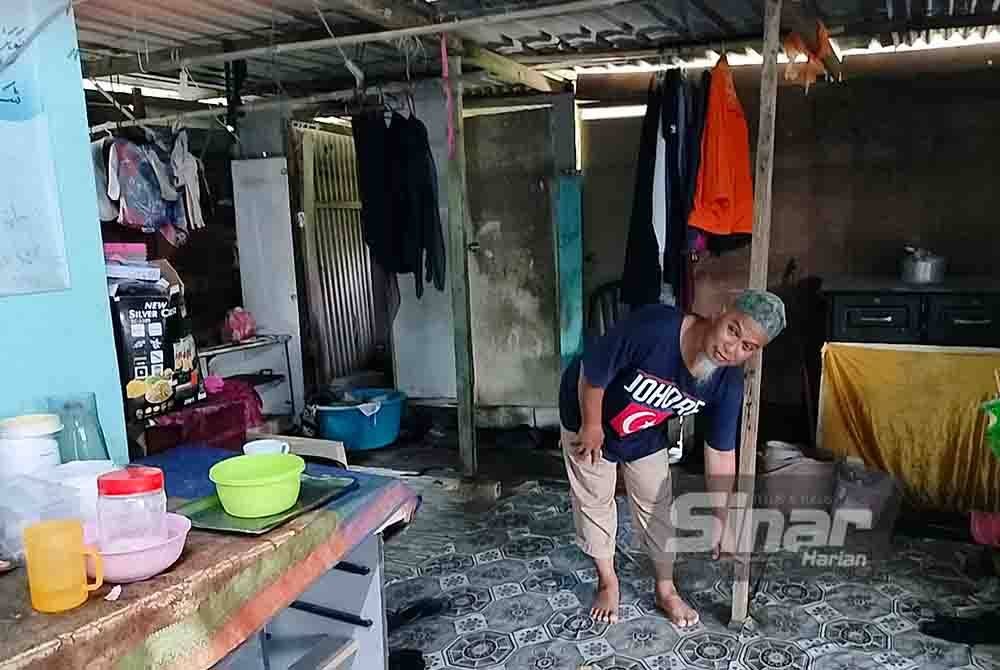 Sulaiman menunjukkan paras air banjir ketika air pasang besar berlaku pada tahun lalu di rumahnya di Kampung Benteng Kanan, Kukup.