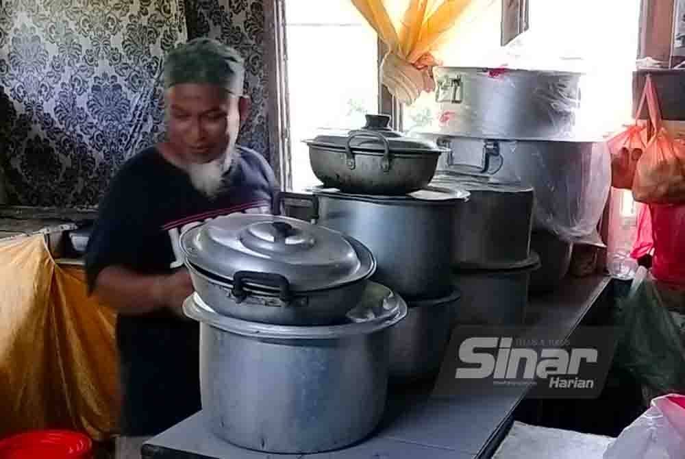 Sulaiman mengemas perkakas dapur di rumahnya sebagai persiapan menghadapi fenomena air pasang besar.