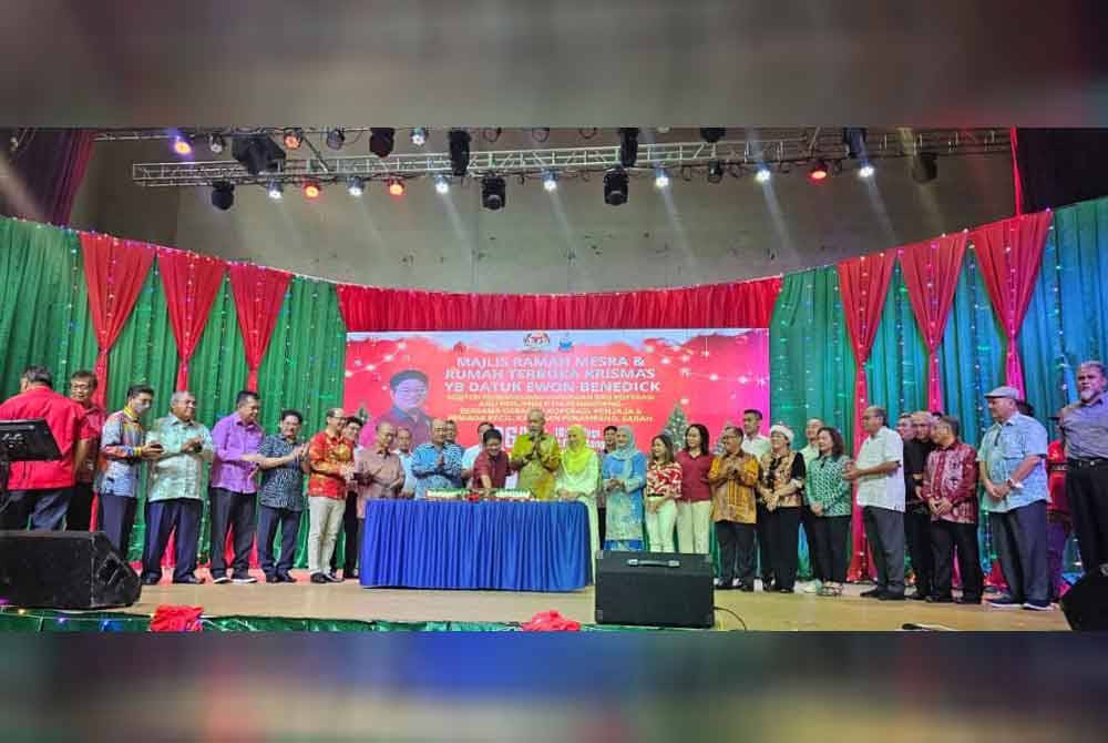 Ewon memotong kek bersama tetamu jemputan sempena Majlis Ramah Mesra dan Rumah Terbuka Krismas di Pusat Kebudayaan Penampang.