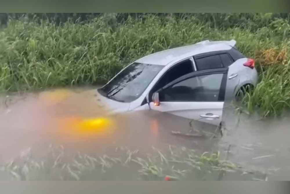 Tangkap layar rakaman video memaparkan sebuah kereta terbabas masuk ke dalam longkang ketika melalui jalan yang dinaiki air di jalan Air Hitam, Pekan.