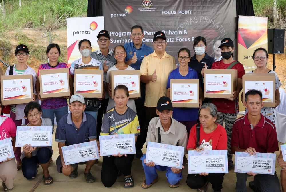 Ewon bersama penduduk Kampung Telungan pada majlis penyampaian sumbangan cermin mata program CSR Pernas Prihatin di Dewan Terbuka Kampung Talungan Kota Belud pada Selasa. Foto Bernama