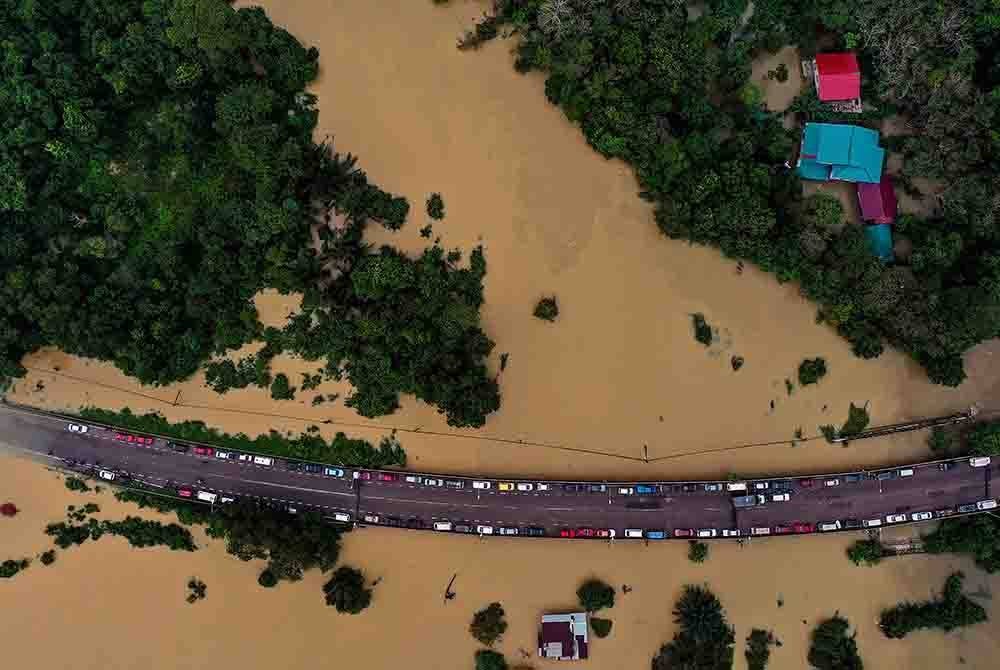 Jalan Kota Bharu-Rantau Panjang berhampiran 'Culvert 5' di Pasir Mas ditutup kepada semua kenderaan berikutan limpahan air separas 0.78meter. - Foto Bernama.