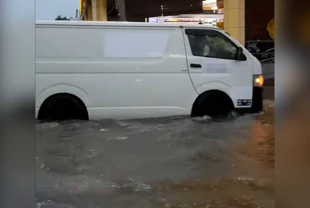 Sebuah van terperangkap banjir di hadapan sebuah premis perkakas rumah.