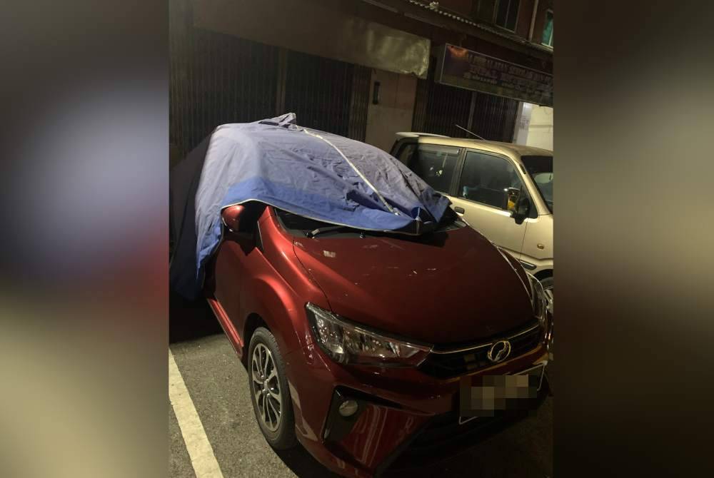 Kenderaan Maziah yang terpaksa ditutup dengan kanvas akibat sampah yang dicampak dari tingkat atas.