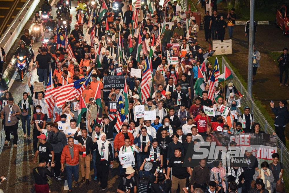 Para peserta himpunan ‘Aksi Bertindak: Kepung Demi Palestin’ berarak dari Menara Tabung Haji hingga ke Kedutaan Besar Amerika Syarikat pada malam Selasa. - Foto Sinar Harian MOHD RAFIQ REDZUAN HAMZAH