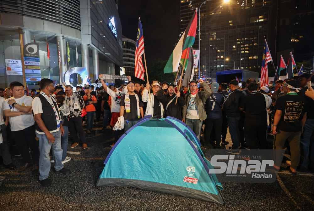 Peserta piket 'Aksi Bertindak: Kepung Demi Palestin' berkumpul sambil mengibarkan bendera Malaysia dan Palestin di sekitar Kedutaan Amerika Syarikat pada Selasa.