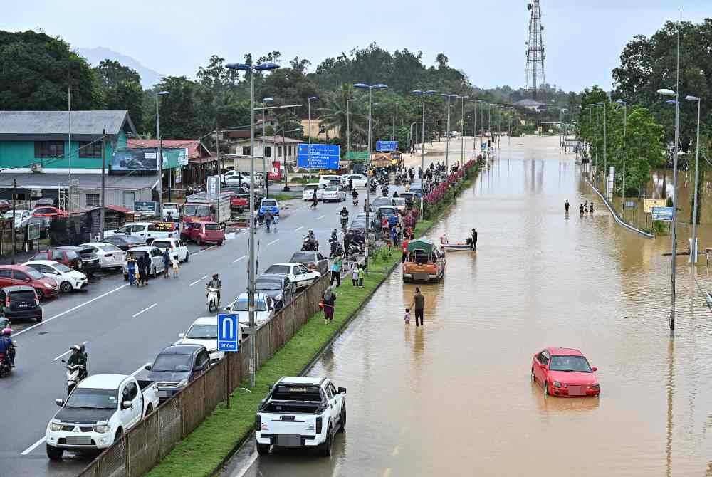 Kenderaan orang ramai terkandas selepas jalan Kuala Berang ke Ajil dinaiki air berikutan hujan lebat ketika tinjauan di Kampung Batu 24, Kuala Berang, Hulu Terengganu pada Selasa. - Foto Bernama