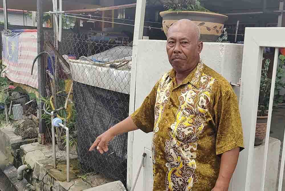 Saidon menunjukkan keadaan longkang hadapan rumah yang sebelum ini dipenuhi air pasang besar dan hujan lebat.