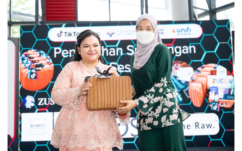 Nur Azre (kiri) menyerahkan sumbangan kepada salah seorang usahawan mikro sempena Majlis Dialog Bersama Usahawan Mikro 2023 di Setapak, Kuala Lumpur pada Khamis.