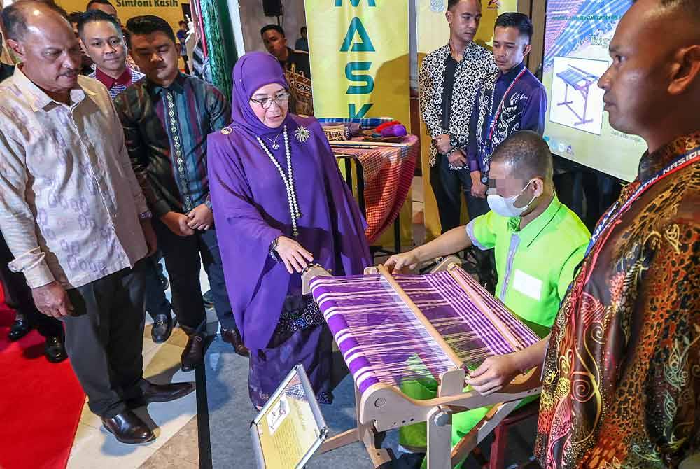 Tunku Azizah berkenan melihat penghuni penjara menenun songket semasa majlis Malam Simfoni Kasih 2023 Jabatan Penjara Malaysia di sini malam ini. - Foto Bernama