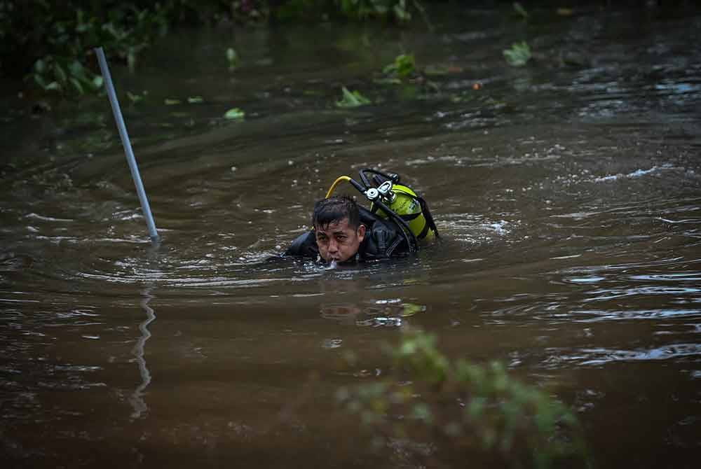 Anggota bomba dan penyelamat dalam misi mencari dan menyelamat (SAR) budak lelaki yang dikhuatiri lemas di Sungai Tok Hakim, Kampung Tok Hakim. - Foto Bernama