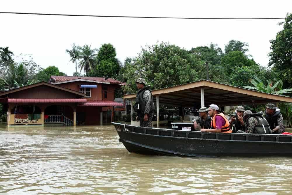 Anggota Batalion 21 Rejimen Askar Melayu Diraja (21 RAMD) Briged Kelapan Infantri Malaysia membantu penduduk Kampung Tasik Ulu, Kampung Tasik Ilir dan Kampung Bendang Guchil yang masih terjejas akibat banjir. - Foto Bernama