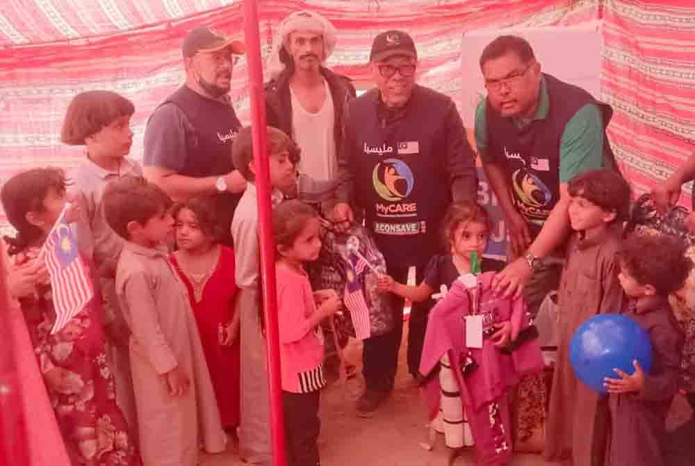 Dr Mohd Zin dan Mas Imran (tengah) menyampaikan bantuan baju sejuk dan selimut kepada mangsa perang di Kem Pelarian Al-Sahn, Marib, Yemen pada Khamis.