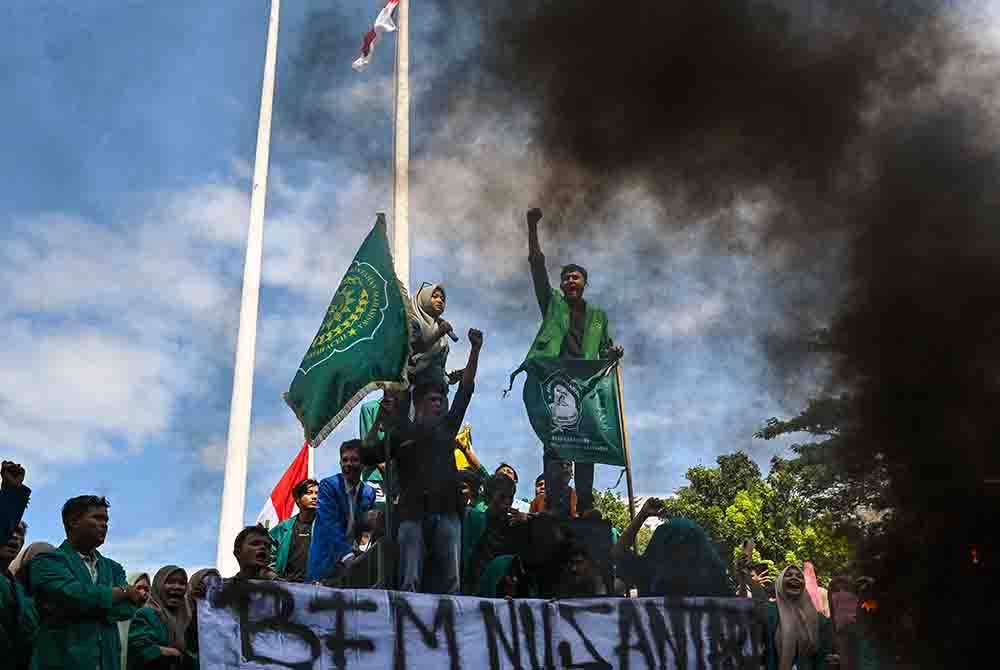 Sekumpulan besar pelajar Indonesia menyerbu pusat penempatan yang diduduki ratusan pelarian Rohingya dari Myanmar di Banda Aceh. - Foto AFP