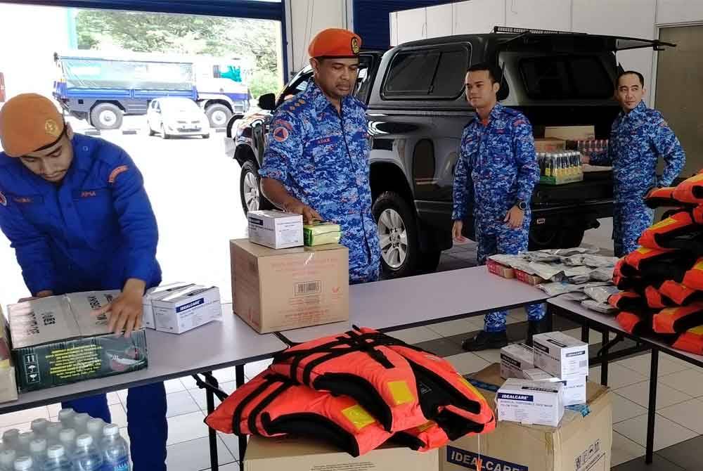 Che Adam (dua dari kiri) meninjau persiapan yang dijalankan di Pusat Pengumpulan Barangan Sumbangan Bencana Pantai Timur di Pejabat APM Pahang pada Khamis.