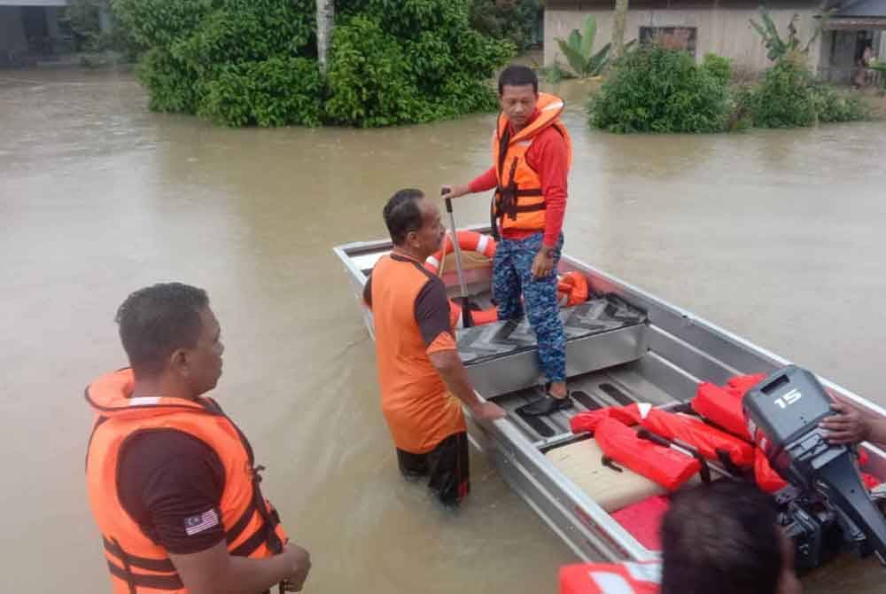 Mohd Bakri (kanan) yang bertugas sebagai anggota APM menggunakan kemahiran serta pengalamannya untuk membantu penduduk kampung.