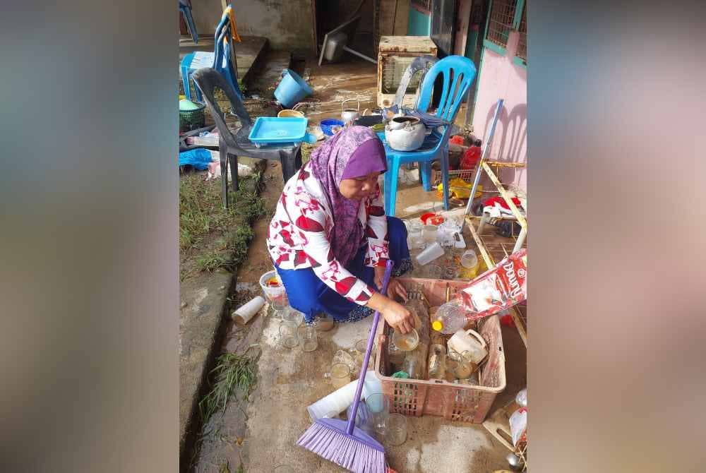 
Fatimah membersihkan barangan yang terjejas akibat banjir